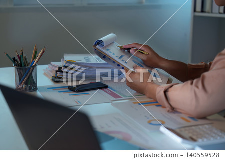 Asian man analyzing financial data and charts at home office 140559528