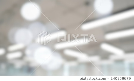 Blurred modern bright office ceiling lighting abstract texture featuring geometric linear circular led lamps arranged across spacious minimalist architectural workspace environment background Blurred modern bright office ceiling lighting abstract texture featuring geometric linear circular led lamps arranged across spacious minimalist architectural workspace environment background 140559679