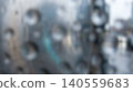 Abstract blurred metallic surface texture featuring circular geometric holes covered with fresh rain drops creating moody atmospheric wet urban city street background 140559683