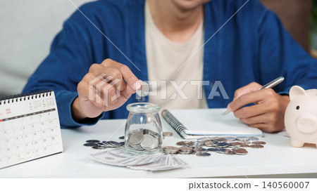 Asian man doing financial planning and budgeting with savings at home Asian man doing financial planning and budgeting with savings at home 140560007