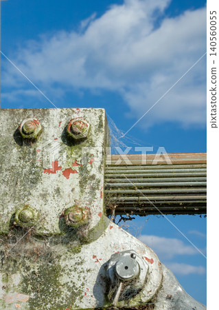 Rusty and deteriorated metal fittings and bolts used to secure the suspension bridge cables. Rusty and deteriorated metal fittings and bolts used to secure the suspension bridge cables. 140560055