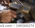 A hunter sharpening a hunting knife. 140560274