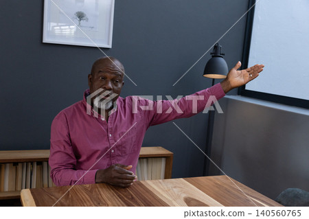 Senior african american man reaching toward window resting on table in office with lamp 140560765