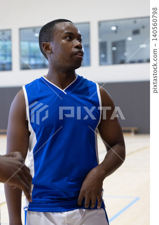 African american male athlete wearing blue jersey receiving high-five from teammate on court African american male athlete wearing blue jersey receiving high-five from teammate on court 140560798