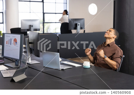 Coworkers celebrating success in office using laptop, calling on smartphone, copy space 140560908