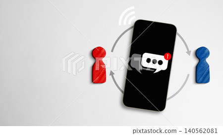 Flat lay of a smartphone showing a chat icon, connected by arrows to red and blue wooden figures, symbolizing digital communication and online messaging Flat lay of a smartphone showing a chat icon, connected by arrows to red and blue wooden figures, symbolizing digital communication and online messaging 140562081