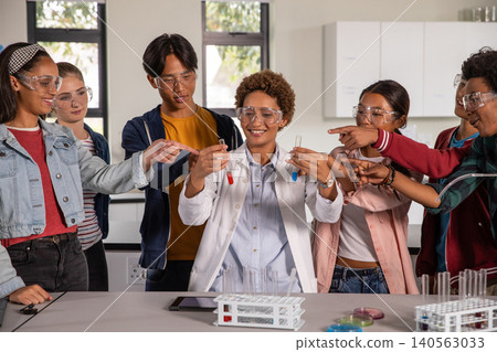 African American teacher with diverse teenage students holding test tubes at science lab bench African American teacher with diverse teenage students holding test tubes at science lab bench 140563033