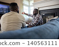 African american male friends discussing baseball on couch at home while watching tv scoreboard 140563111