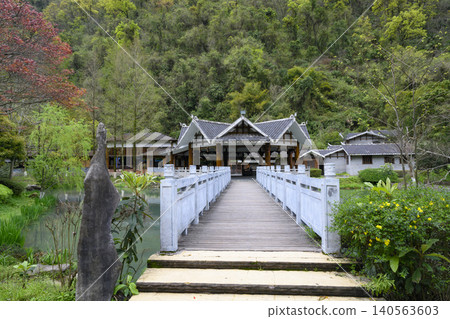 Bridge and wooden buildings in Yellow Dragon Park in mountains near Zhangjiajie City, China Bridge and wooden buildings in Yellow Dragon Park in mountains near Zhangjiajie City, China 140563603