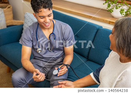 Male nurse checking blood pressure on senior female patient at home Male nurse checking blood pressure on senior female patient at home 140564238