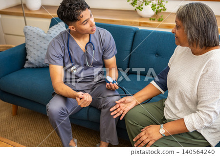 African american senior woman, medical professional getting pressure check with cuff African american senior woman, medical professional getting pressure check with cuff 140564240