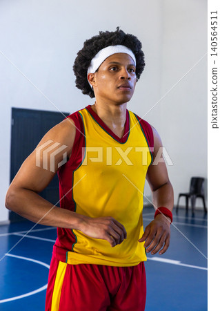 African american male athlete warming up on blue court wearing headband, wristband and uniform African american male athlete warming up on blue court wearing headband, wristband and uniform 140564511