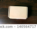 Blank Cardboard Shipping Box on Wooden Surface 140564717