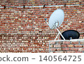 Satellite TV Dish Antenna Mounted on a Rooftop 140564725