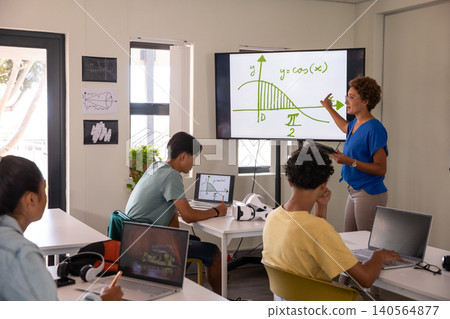 African american female instructor pointing at cosine curve on classroom display screen African american female instructor pointing at cosine curve on classroom display screen 140564877