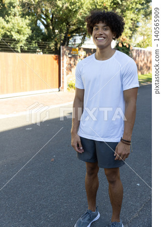 African american man standing on street in bright sunlight, wearing athletic African american man standing on street in bright sunlight, wearing athletic 140565909