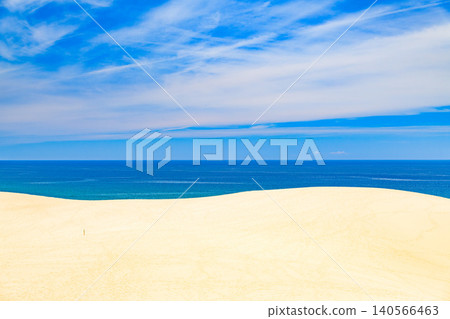 On a clear summer day, a view of the vast Tottori Sand Dunes, devoid of tourists, overlooks the blue Sea of Japan and a summer sky filled with wispy clouds—a deserted landscape. On a clear summer day, a view of the vast Tottori Sand Dunes, devoid of tourists, overlooks the blue Sea of Japan and a summer sky filled with wispy clouds—a deserted landscape. 140566463