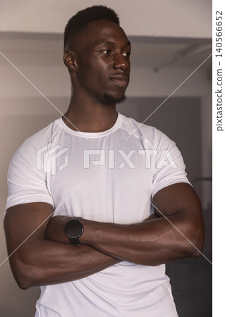 African American male standing by support bar in fitness studio wearing shirt and smartwatch African American male standing by support bar in fitness studio wearing shirt and smartwatch 140566652