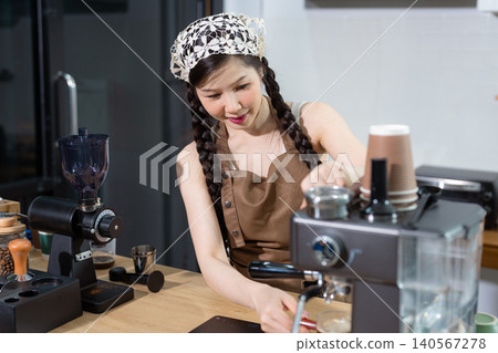 Young barista making coffee, coffee preparation service concept. Young barista making coffee, coffee preparation service concept. 140567278