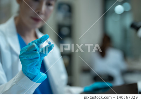 Asian environmental scientists analyzing water quality samples with centrifuge and petri dish in laboratory. Asian environmental scientists analyzing water quality samples with centrifuge and petri dish in laboratory. 140567329