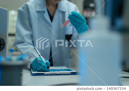 Team Asian environmental scientists analyzing water quality samples with centrifuge and petri dish in laboratory. Team Asian environmental scientists analyzing water quality samples with centrifuge and petri dish in laboratory. 140567334