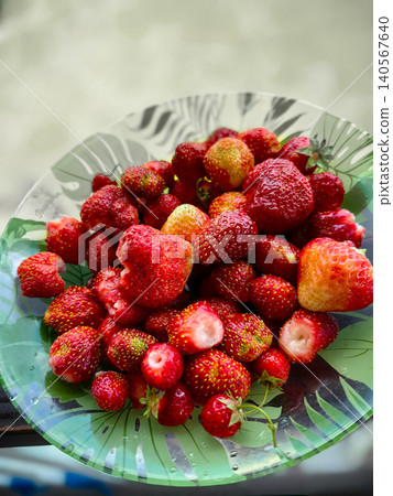 Fresh ripe strawberries in a decorative glass bowl on a wooden surface. Fresh ripe strawberries in a decorative glass bowl on a wooden surface. 140567640