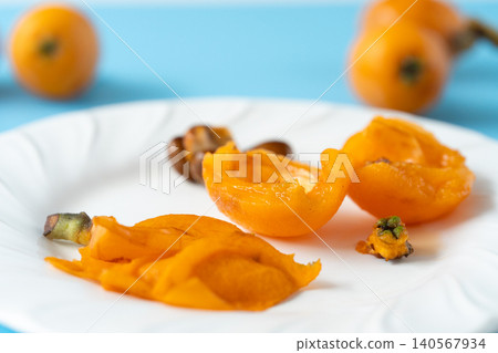 Peeled, organic loquats with irregular shapes. Place the flesh, seeds, peel, and hilum on a plate. Peeled, organic loquats with irregular shapes. Place the flesh, seeds, peel, and hilum on a plate. 140567934
