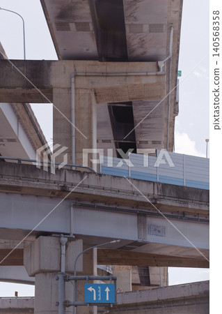 Low Angle View of Urban Freeway Interchange with Blue Direction Sign Low Angle View of Urban Freeway Interchange with Blue Direction Sign 140568358