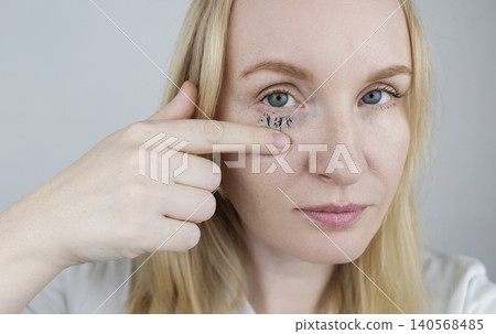 Woman demonstrating easy tubing mascara removal process using warm water. Woman washing off innovative thermal cosmetics that slides off eyelashes in tubes without smudging Woman demonstrating easy tubing mascara removal process using warm water. Woman washing off innovative thermal cosmetics that slides off eyelashes in tubes without smudging 140568485