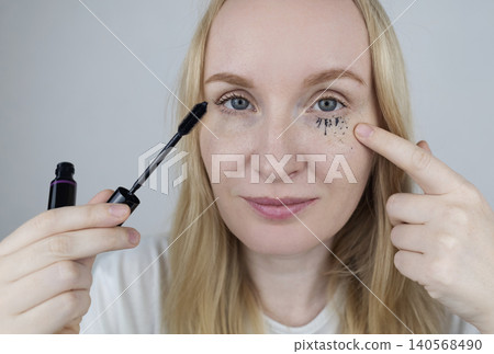 Woman demonstrating easy tubing mascara removal process using warm water. Woman washing off innovative thermal cosmetics that slides off eyelashes in tubes without smudging Woman demonstrating easy tubing mascara removal process using warm water. Woman washing off innovative thermal cosmetics that slides off eyelashes in tubes without smudging 140568490