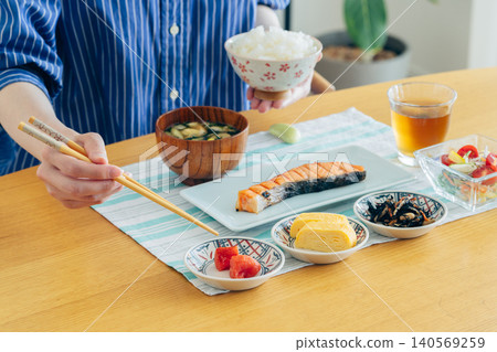 Hand of young woman eating breakfast Hand of young woman eating breakfast 140569259
