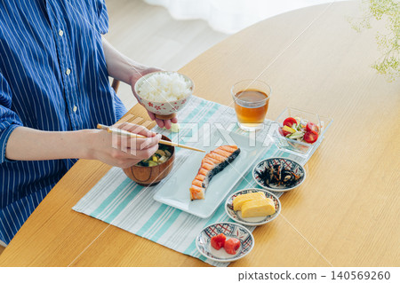 Hand of young woman eating breakfast Hand of young woman eating breakfast 140569260