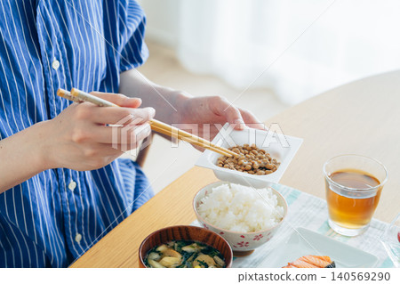 A young woman's hands as she eats natto A young woman's hands as she eats natto 140569290