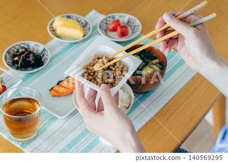 A young woman's hands as she eats natto A young woman's hands as she eats natto 140569295