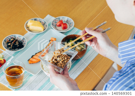 A young woman's hands as she eats natto A young woman's hands as she eats natto 140569301