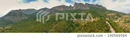 Panoramic view from above of the valley and the mountain ridge during sunrise. Coves del Canelobre near Busot, Alicante, Spain Panoramic view from above of the valley and the mountain ridge during sunrise. Coves del Canelobre near Busot, Alicante, Spain 140569564