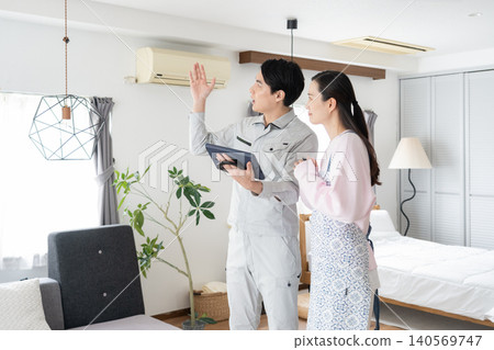 A housewife and a construction worker discussing renovation plans. A housewife and a construction worker discussing renovation plans. 140569747