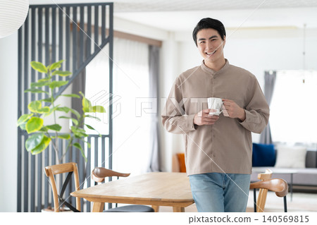 A man drinking coffee in the living room in the morning. A man drinking coffee in the living room in the morning. 140569815