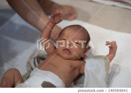 A 10-day-old newborn being dressed by his dad. A 10-day-old newborn being dressed by his dad. 140569841