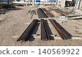 Bundles of steel rebar arranged at a construction site with unfinished concrete structures, representing building development, engineering project, and urban growth 140569922