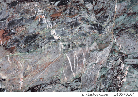 Natural stone surface showing patterns and colors found in a quarry or geological site during daytime hours 140570104