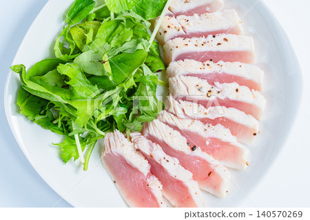 Rare-cooked tuna steak served with baby greens. Rare-cooked tuna steak served with baby greens. 140570269