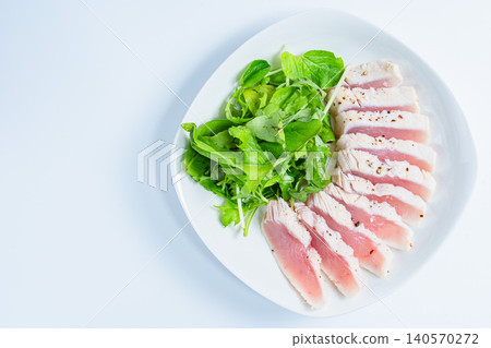Rare-cooked tuna steak served with baby greens. Rare-cooked tuna steak served with baby greens. 140570272