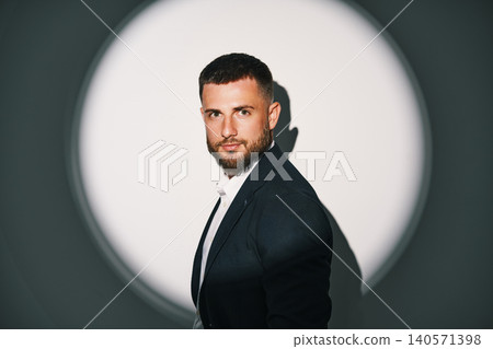 Elegant businessman in black suit under spotlight Elegant businessman in black suit under spotlight 140571398