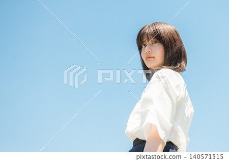 一名身穿校服的高中女生回頭望向藍天。 140571515
