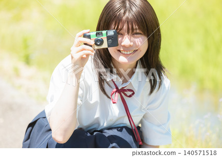 一名高中女生正透過相機看著什麼 140571518