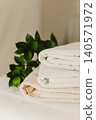 Minimalist still life of luxury spa essentials. White cotton towels with visible textured on a table. 140571972