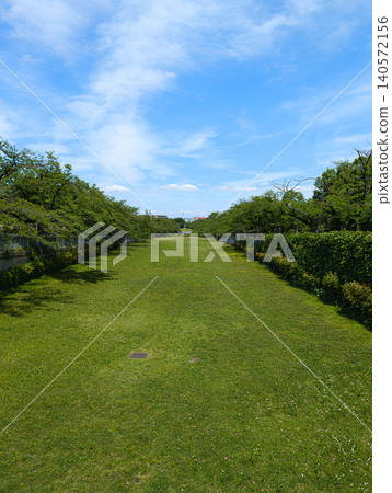 一個擁有藍天和廣闊草坪的公園。 一個擁有藍天和廣闊草坪的公園。 140572156