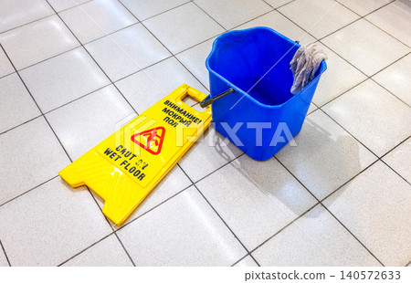 Caution Wet Floor warning sign on a tile floor Caution Wet Floor warning sign on a tile floor 140572633
