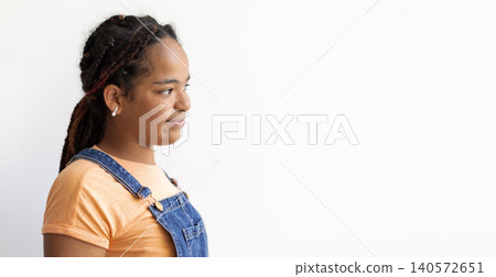 Profile closeup portrait of smiling black teenage girl looking toward copy space Profile closeup portrait of smiling black teenage girl looking toward copy space 140572651